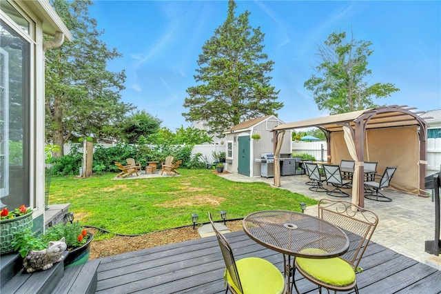 82 Martin St, East Providence, RI 02914 - fenced backyard with outdoor dining space, an outdoor fire pit, a patio area, and a shed