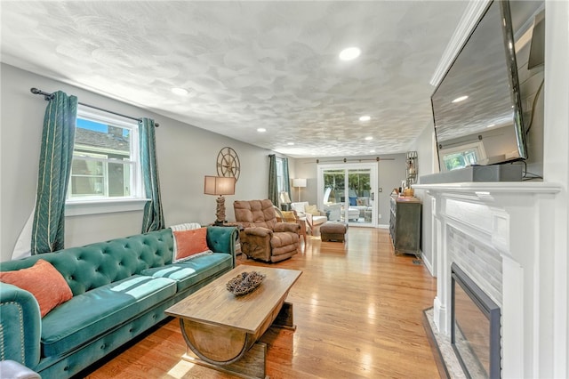 82 Martin St, East Providence, RI 02914 - living area featuring a tile fireplace, recessed lighting, light wood-type flooring, and healthy amount of natural light