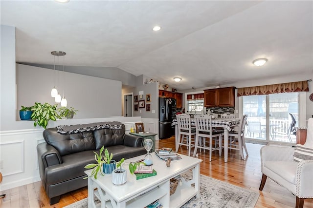 10 Pembroke Dr, Johnston, RI 02919 - living area with lofted ceiling, a wainscoted wall, light wood-style floors, and a decorative wall