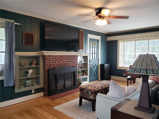603 Wakefield St, West Warwick, RI 02893 - living area with a brick fireplace, light wood finished floors, ceiling fan, and crown molding