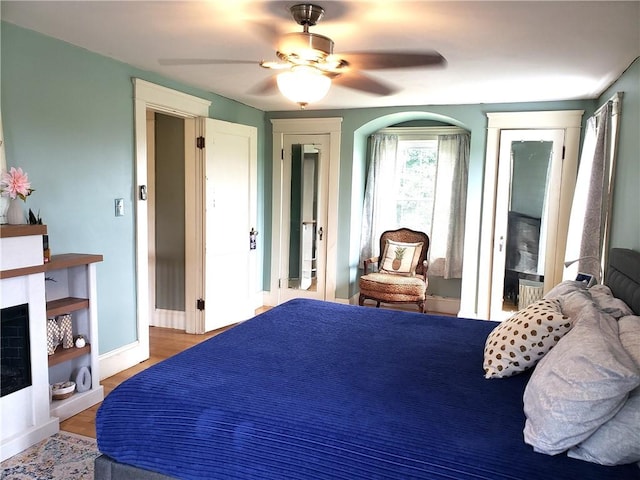 603 Wakefield St, West Warwick, RI 02893 - bedroom with wood finished floors, a ceiling fan, and a fireplace