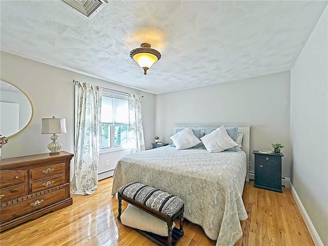 15 Lilac Cir, Cranston, RI 02920 - bedroom featuring a baseboard radiator, wood finished floors, and a textured ceiling