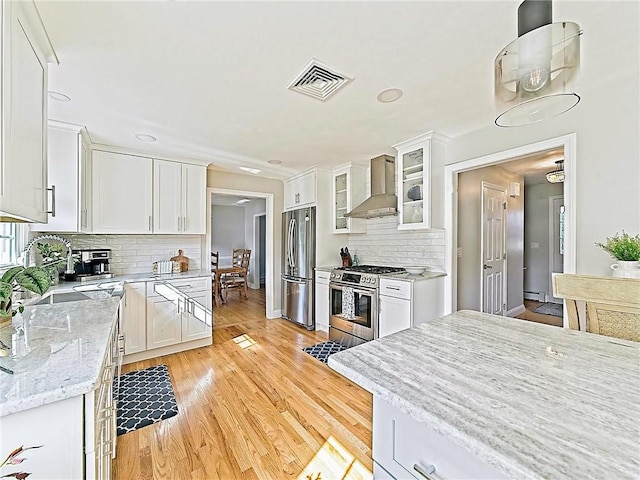 15 Lilac Cir, Cranston, RI 02920 - kitchen with appliances with stainless steel finishes, wall chimney range hood, light wood-style floors, white cabinetry, and recessed lighting