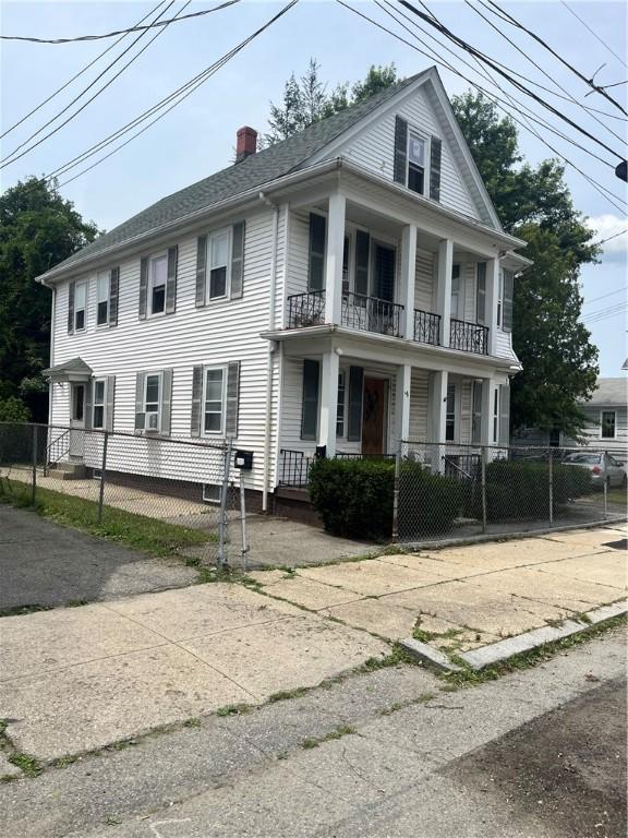 38 Moorefield St, Providence, RI 02909 - view of front of house with a balcony, a chimney, a porch, and a gate