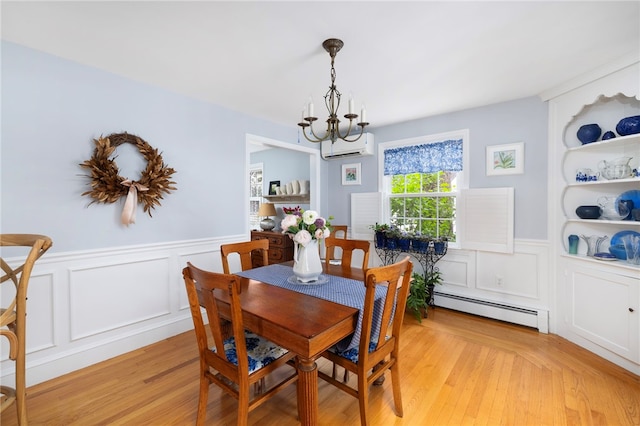221 Trinity St, Warwick, RI 02886 - dining area with a baseboard radiator, a chandelier, a decorative wall, wainscoting, and a wall mounted air conditioner