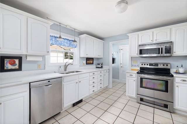 221 Trinity St, Warwick, RI 02886 - kitchen featuring stainless steel appliances, white cabinets, light countertops, and light tile patterned floors