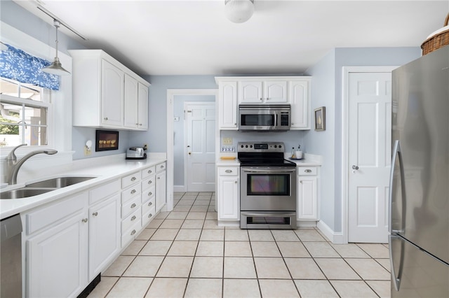 221 Trinity St, Warwick, RI 02886 - kitchen with stainless steel appliances, white cabinetry, light tile patterned flooring, light countertops, and decorative light fixtures