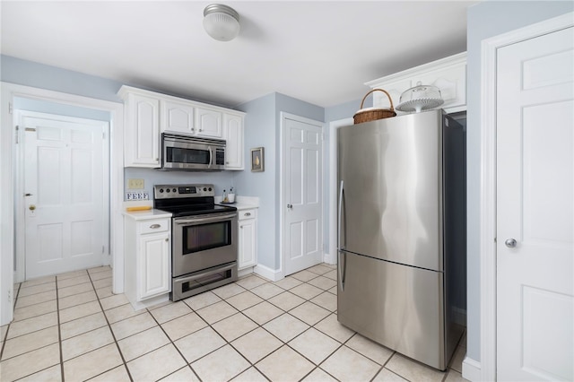 221 Trinity St, Warwick, RI 02886 - kitchen featuring stainless steel appliances, light countertops, white cabinetry, and light tile patterned floors