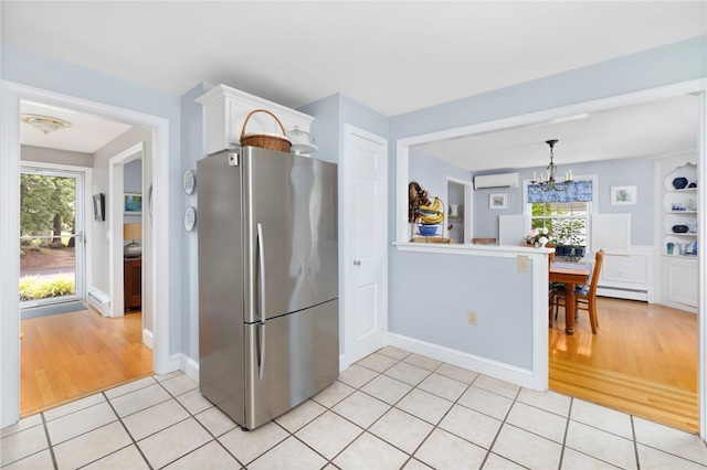 221 Trinity St, Warwick, RI 02886 - kitchen featuring freestanding refrigerator, a wall mounted air conditioner, a chandelier, light tile patterned flooring, and healthy amount of natural light
