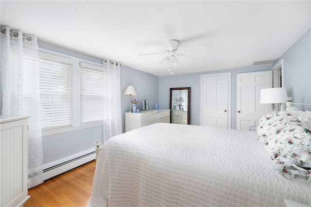 221 Trinity St, Warwick, RI 02886 - bedroom featuring baseboard heating, light wood-type flooring, and a ceiling fan