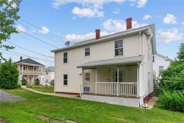 10 Foundry St, Central Falls, RI 02863 - back of house featuring covered porch, a lawn, and a chimney