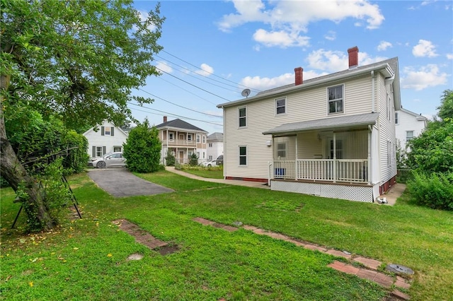 10 Foundry St, Central Falls, RI 02863 - back of property featuring a chimney, a lawn, and covered porch