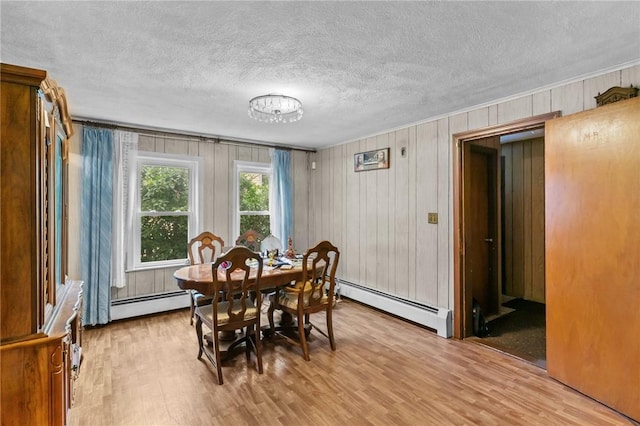 10 Foundry St, Central Falls, RI 02863 - dining space featuring a baseboard heating unit, light wood finished floors, a textured ceiling, and wooden walls