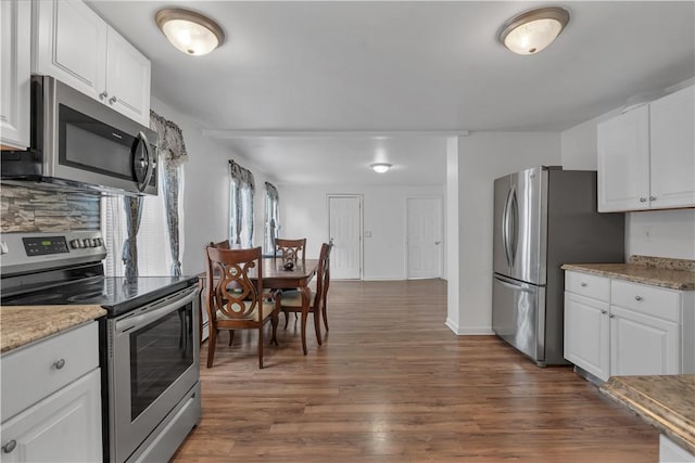 1 Ware St, Providence, RI 02907 - kitchen with stainless steel appliances, dark wood finished floors, white cabinets, tasteful backsplash, and light stone counters
