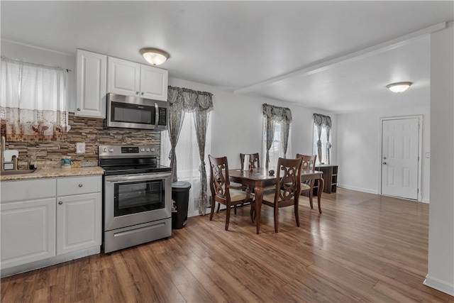 1 Ware St, Providence, RI 02907 - kitchen featuring stainless steel appliances, backsplash, wood finished floors, and white cabinets