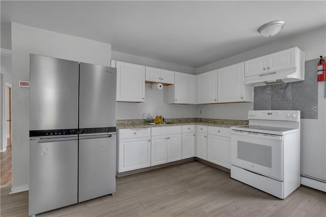 1 Ware St, Providence, RI 02907 - kitchen with freestanding refrigerator, white electric range, under cabinet range hood, a baseboard radiator, and white cabinets