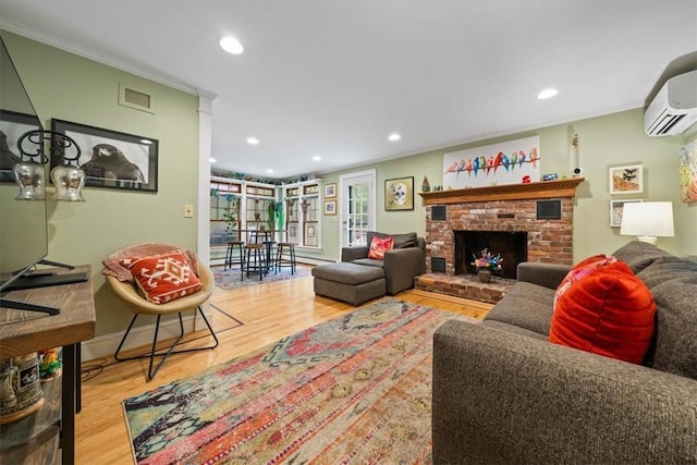 825 Matteson Rd, Coventry, RI 02816 - living area featuring wood finished floors, a wall mounted AC, recessed lighting, a brick fireplace, and crown molding
