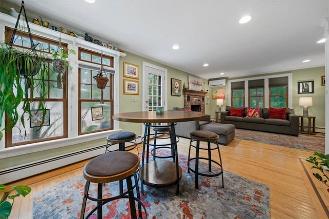 825 Matteson Rd, Coventry, RI 02816 - dining space with a wall mounted AC, a fireplace, wood finished floors, recessed lighting, and baseboard heating