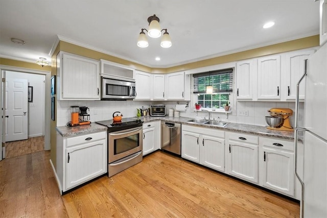 825 Matteson Rd, Coventry, RI 02816 - kitchen featuring stainless steel appliances, ornamental molding, white cabinetry, decorative backsplash, and light wood-type flooring