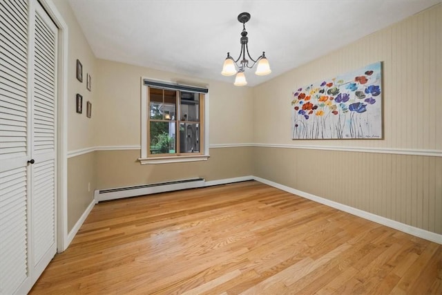 825 Matteson Rd, Coventry, RI 02816 - empty room featuring baseboard heating, wood finished floors, and a chandelier
