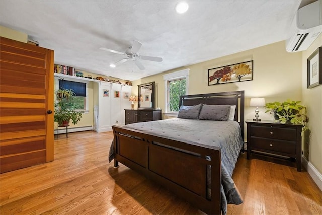 825 Matteson Rd, Coventry, RI 02816 - bedroom featuring a wall unit AC, baseboard heating, wood finished floors, and a ceiling fan