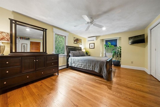 825 Matteson Rd, Coventry, RI 02816 - bedroom with a wall mounted AC, a baseboard heating unit, light wood-type flooring, and ceiling fan