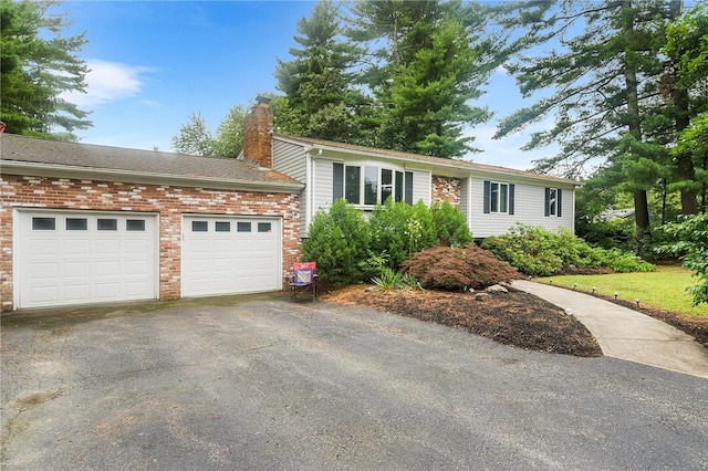 18 Magnolia Ln, Coventry, RI 02816 - ranch-style home featuring a chimney, asphalt driveway, an attached garage, and brick siding