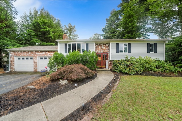 18 Magnolia Ln, Coventry, RI 02816 - raised ranch featuring driveway, a chimney, a garage, brick siding, and french doors