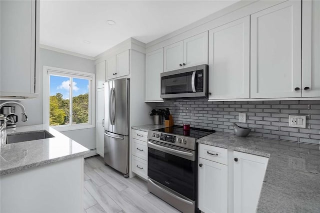 400 Narragansett Pkwy Unit Sb9, Warwick, RI 02888 - kitchen featuring appliances with stainless steel finishes, decorative backsplash, white cabinets, light stone countertops, and crown molding