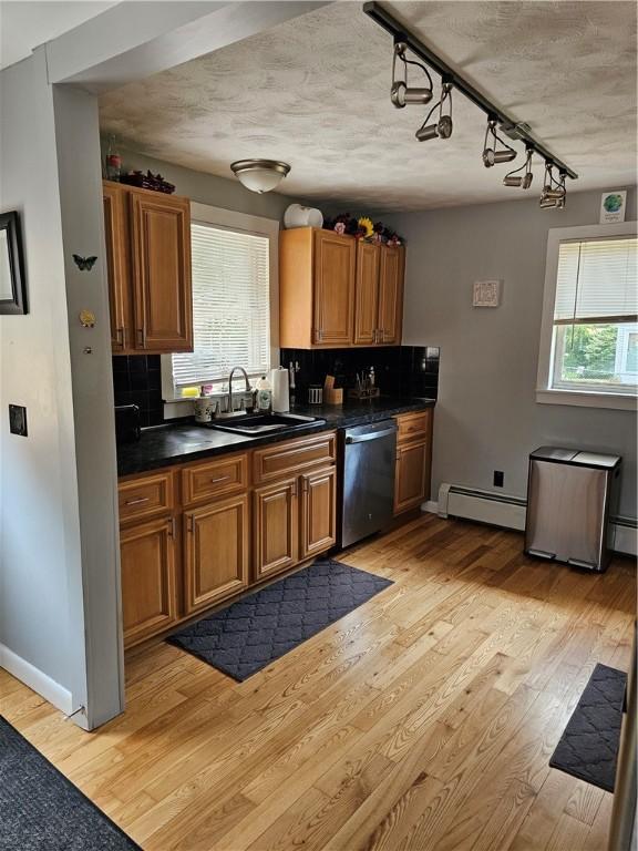 250 Arnold Rd, Coventry, RI 02816 - kitchen with dishwasher, a baseboard radiator, brown cabinets, light wood finished floors, and dark countertops
