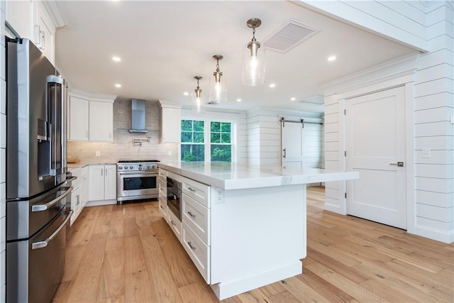 5 Williams St Unit 4, Warwick, RI 02818 - kitchen featuring premium appliances, wall chimney range hood, a barn door, white cabinetry, and recessed lighting