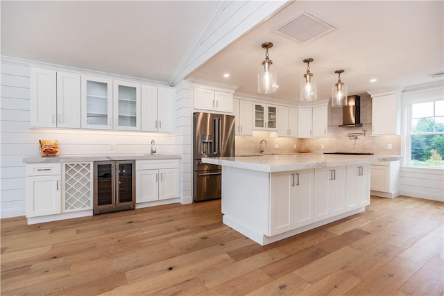 5 Williams St Unit 4, Warwick, RI 02818 - kitchen with high end fridge, beverage cooler, wall chimney exhaust hood, light wood finished floors, and white cabinetry