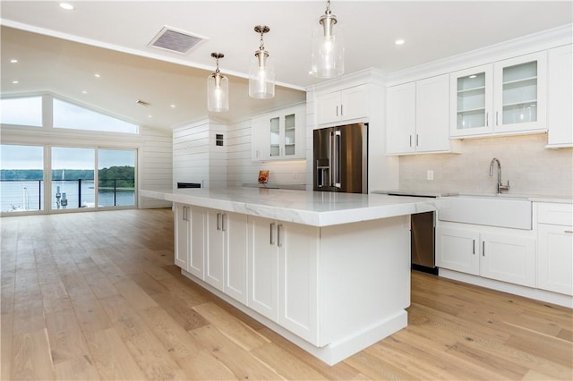 5 Williams St Unit 4, Warwick, RI 02818 - kitchen featuring high quality fridge, backsplash, white cabinetry, light wood-style floors, and vaulted ceiling