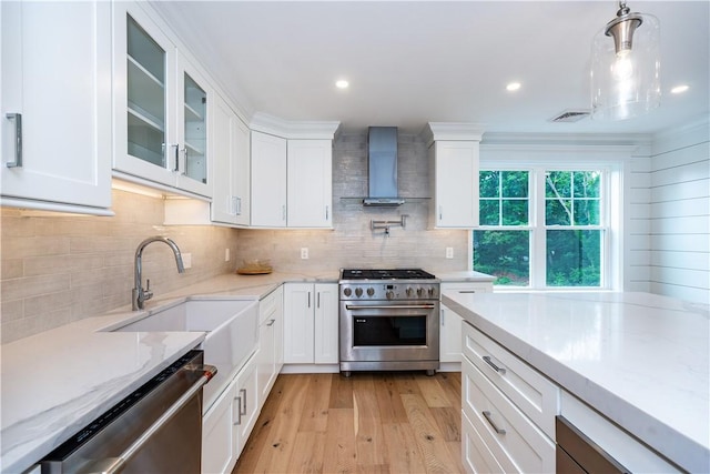 5 Williams St Unit 4, Warwick, RI 02818 - kitchen with appliances with stainless steel finishes, wall chimney range hood, light wood-style floors, white cabinets, and backsplash