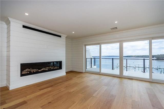 5 Williams St Unit 4, Warwick, RI 02818 - unfurnished living room with crown molding, light wood-type flooring, a large fireplace, a water view, and recessed lighting