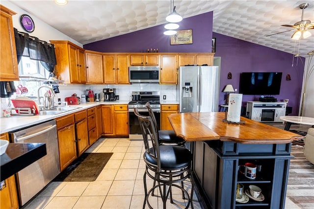 61 Cyr St, Providence, RI 02905 - kitchen with stainless steel appliances, lofted ceiling, ceiling fan, decorative backsplash, and light tile patterned flooring
