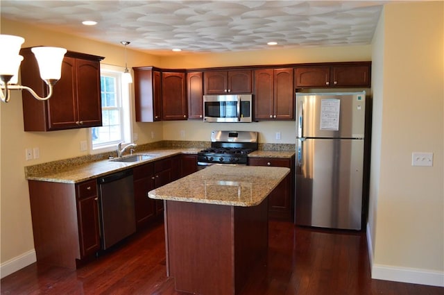 75 Esmond St Unit 5D, West Warwick, RI 02893 - kitchen featuring stainless steel appliances, dark wood finished floors, a center island, light stone counters, and pendant lighting