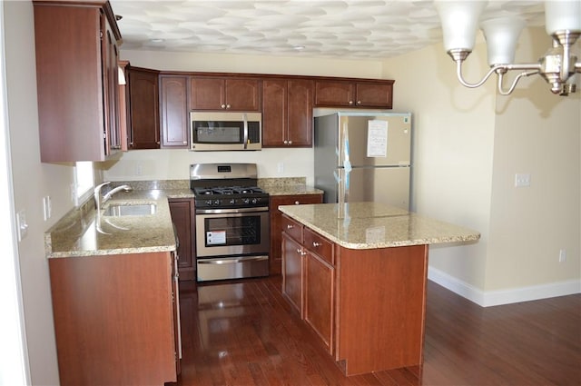 75 Esmond St Unit 5D, West Warwick, RI 02893 - kitchen with stainless steel appliances, dark wood-type flooring, a center island, and light stone countertops