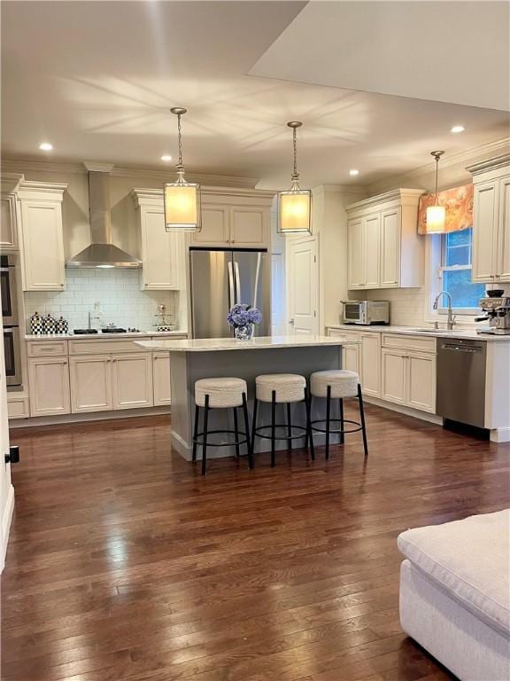 21 Helm St, Jamestown, RI 02835 - kitchen with appliances with stainless steel finishes, wall chimney exhaust hood, a breakfast bar area, a kitchen island, and dark wood-style floors