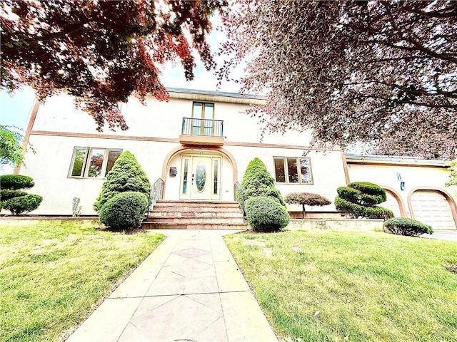 74 Plymouth Rd, East Providence, RI 02914 - mediterranean / spanish-style house with a balcony, stucco siding, and a front lawn