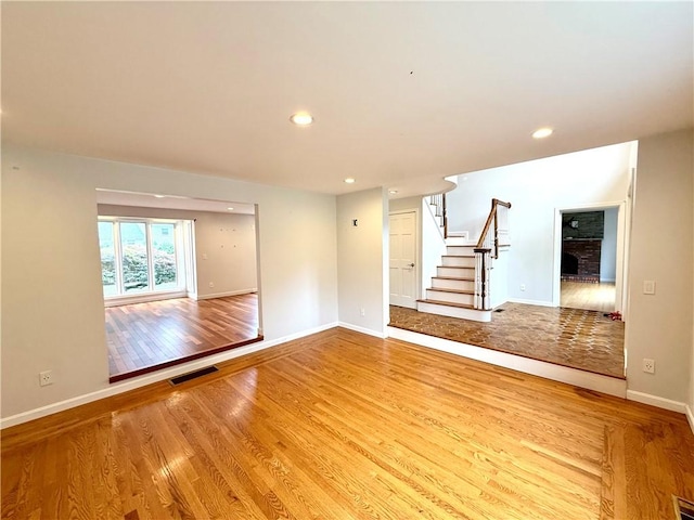74 Plymouth Rd, East Providence, RI 02914 - unfurnished room featuring wood finished floors, a fireplace, stairs, and recessed lighting