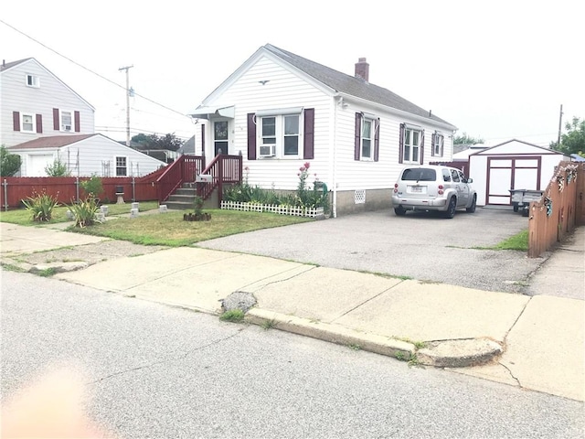 16 Edgemere Rd, Pawtucket, RI 02861 - view of front of house with an outdoor structure, a chimney, and driveway