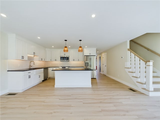 7 Carolina Nooseneck Rd Unit C, Richmond, RI 02898 - kitchen with stainless steel appliances, recessed lighting, dark countertops, light wood finished floors, and white cabinets