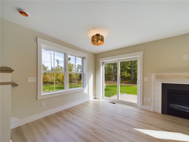 7 Carolina Nooseneck Rd Unit C, Richmond, RI 02898 - unfurnished living room with wood finished floors and a glass covered fireplace