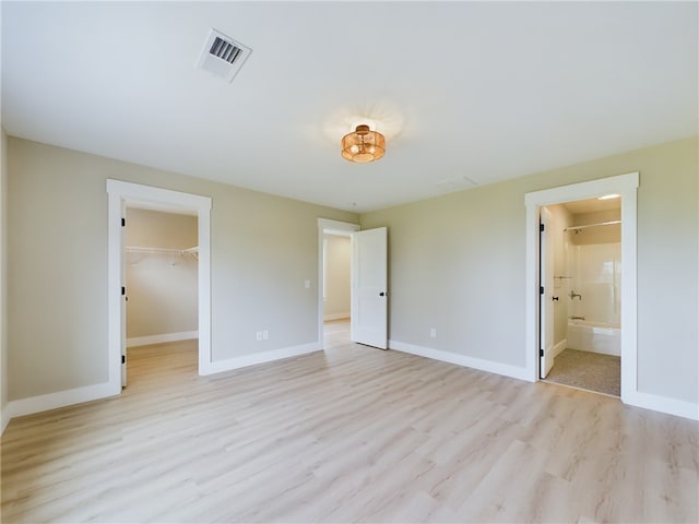 7 Carolina Nooseneck Rd Unit C, Richmond, RI 02898 - unfurnished bedroom featuring light wood-style flooring, a spacious closet, and ensuite bathroom
