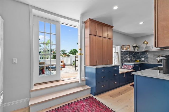 519 Bellevue Ave Unit 2N, Newport, RI 02840 - kitchen with light wood-type flooring, backsplash, blue cabinetry, open shelves, and recessed lighting