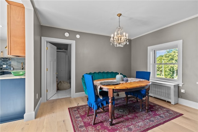 519 Bellevue Ave Unit 2N, Newport, RI 02840 - dining room with radiator, a chandelier, light wood finished floors, and crown molding