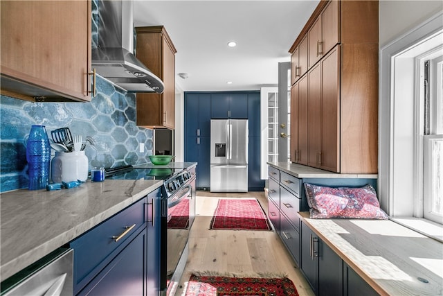 519 Bellevue Ave Unit 2N, Newport, RI 02840 - kitchen with stainless steel appliances, wall chimney exhaust hood, light wood-style flooring, backsplash, and light stone counters