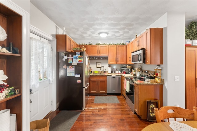 18 N Main St, Coventry, RI 02816 - kitchen with stainless steel appliances, light countertops, dark wood-type flooring, a textured ceiling, and brown cabinets