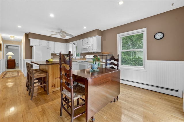 435 Allen Ave, South Kingstown, RI 02879 - kitchen featuring a baseboard heating unit, wainscoting, white appliances, white cabinetry, and light wood-style floors